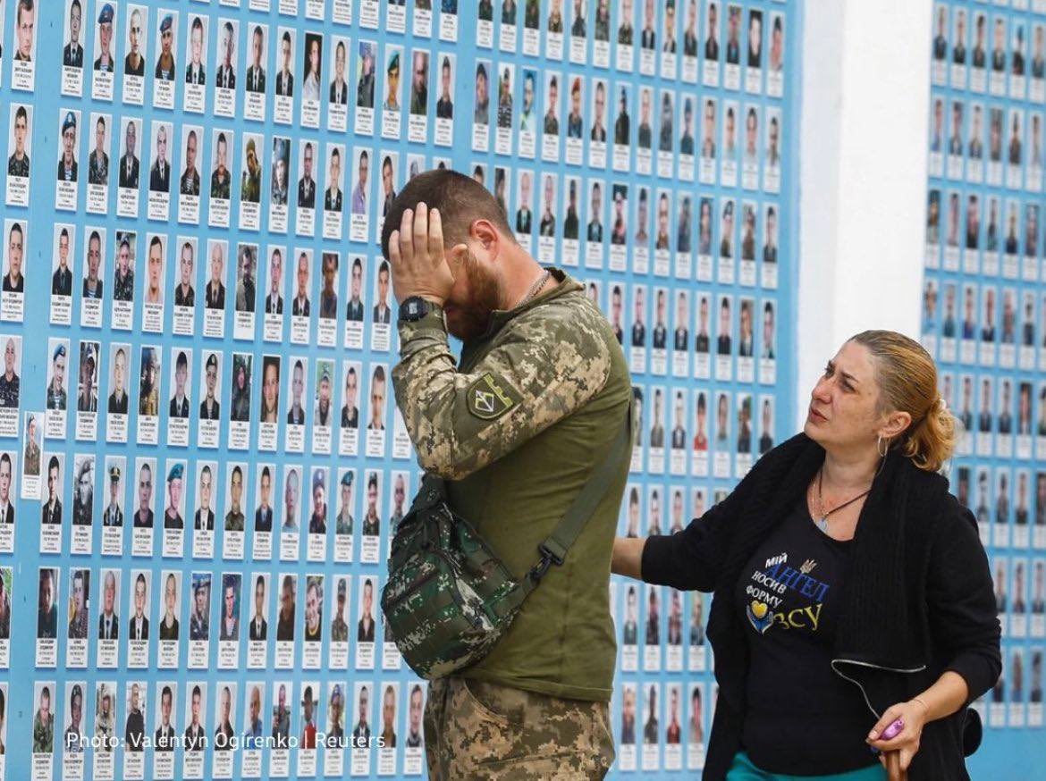 A Ukrainian soldier at the memorial wall for fallen defenders of Ukraine in Kyiv.jpg