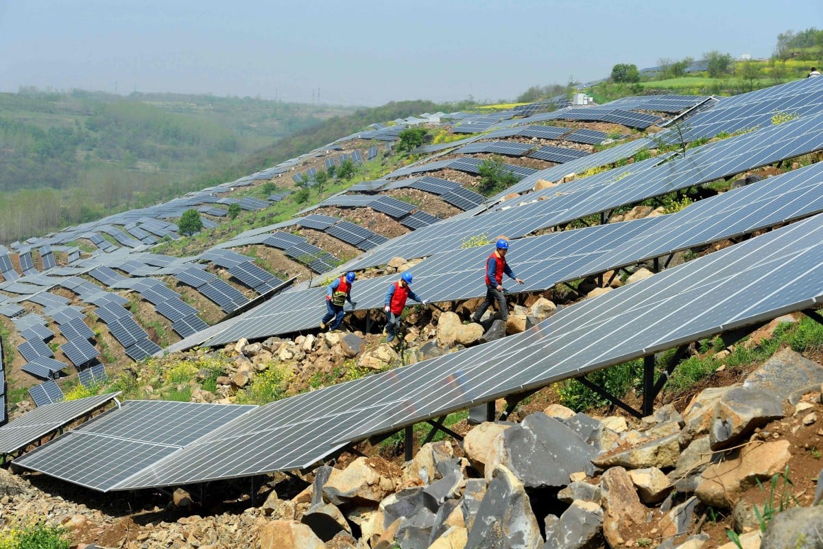 Chinese workers check solar panels on a hillside in Anhui province. China is encouraging a transition towards a green economy and financial system, rather than the more diffuse approaches taken in the US, Europe and Japan. (Photo: AFP)