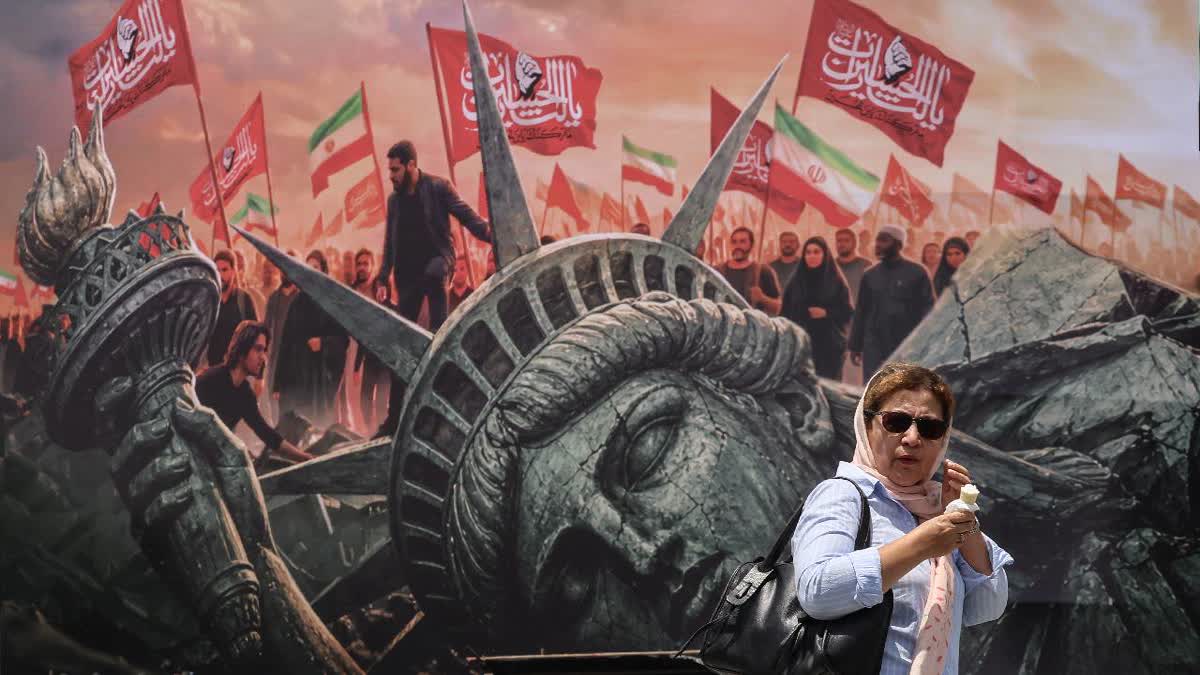 An Iranian woman walks past an anti-US billboard at Enghelab Square in central Tehran on August 3, 2026. (AFP).jpg